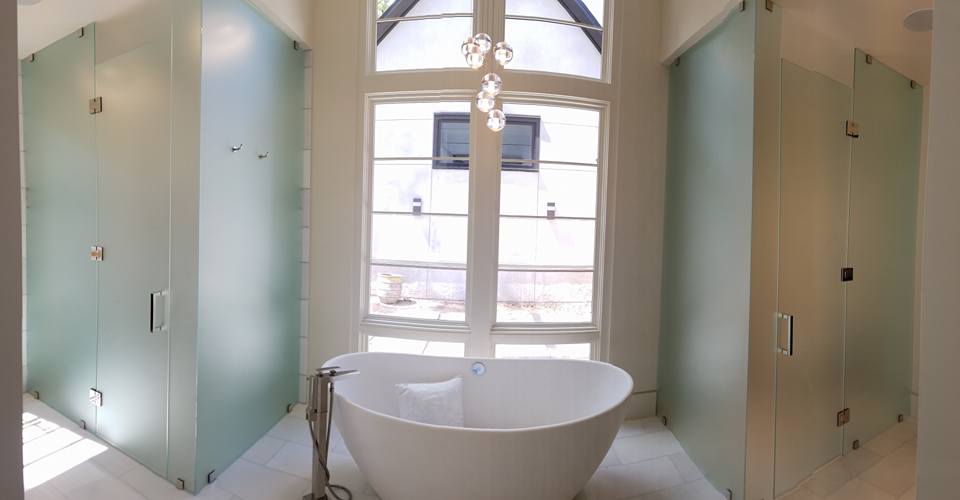Stand alone tub with foggy glass showers on both sides
