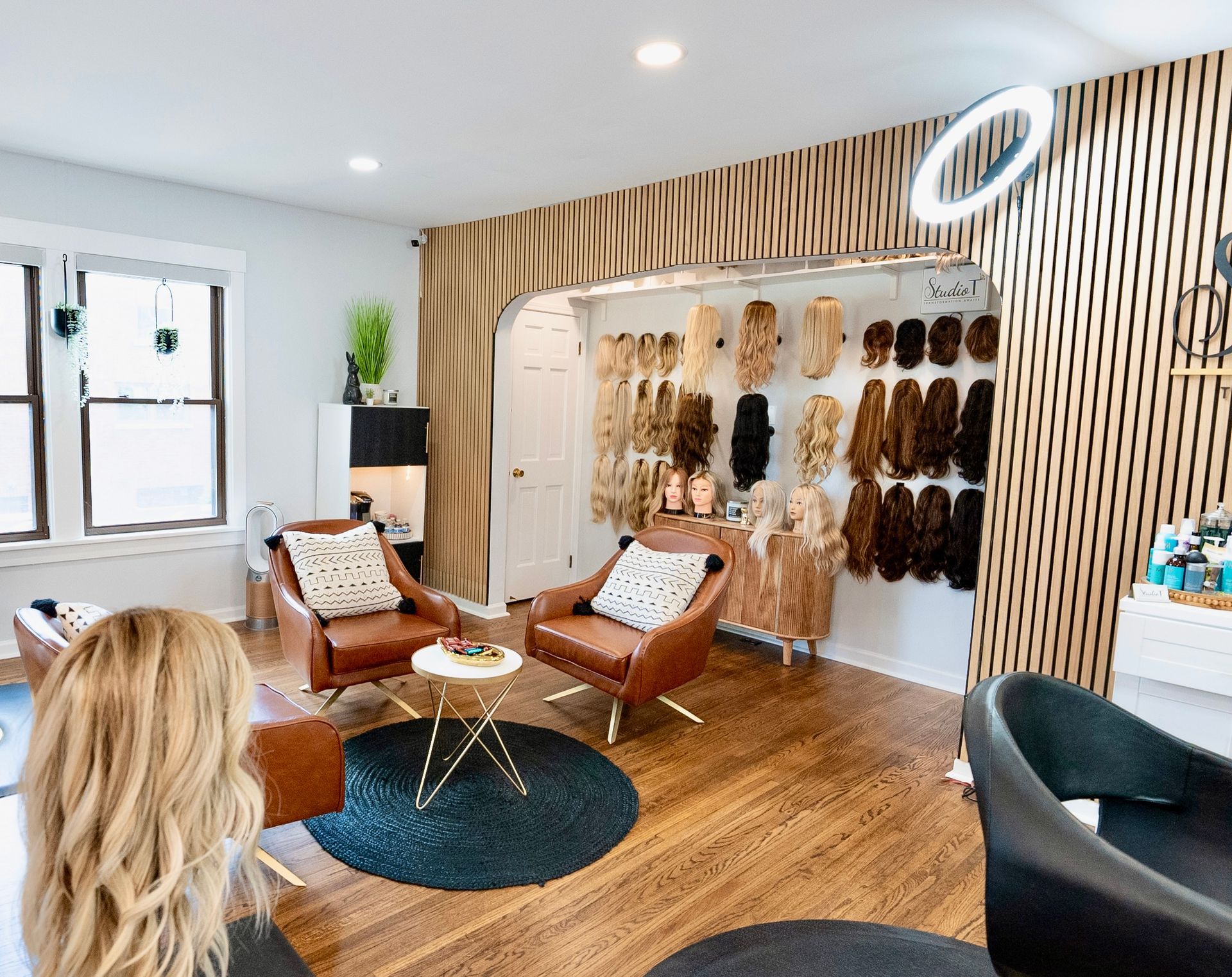 A woman is sitting in a chair in a salon looking at her hair.