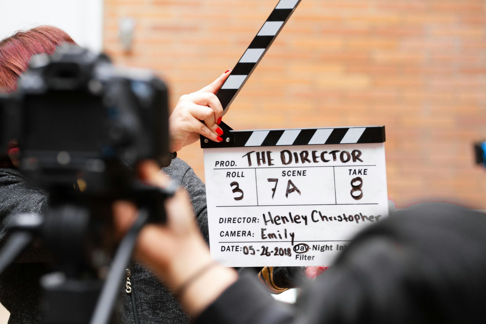 A person is holding a clapper board that says the director on it.