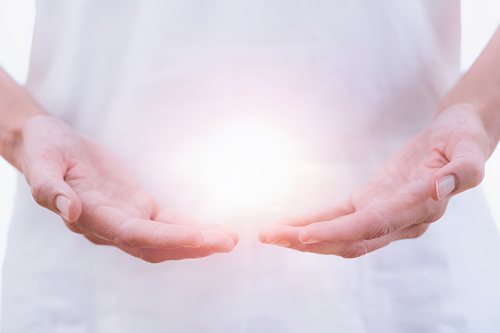 A Person Is Holding A Light In Their Hands — Essy K Counselling And Wellness Hub In Croudace Bay NSW