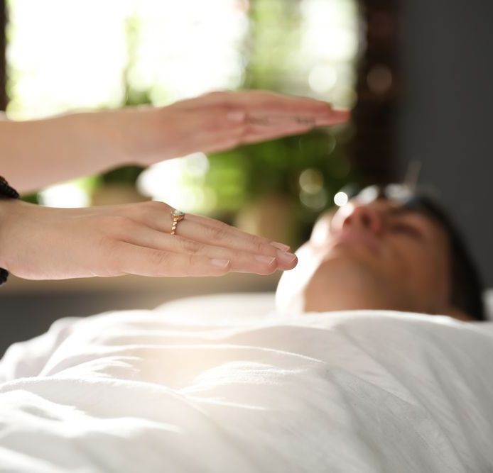 A person laying on a bed with their hands outstretched — Essy K Counselling And Wellness Hub In Croudace Bay NSW