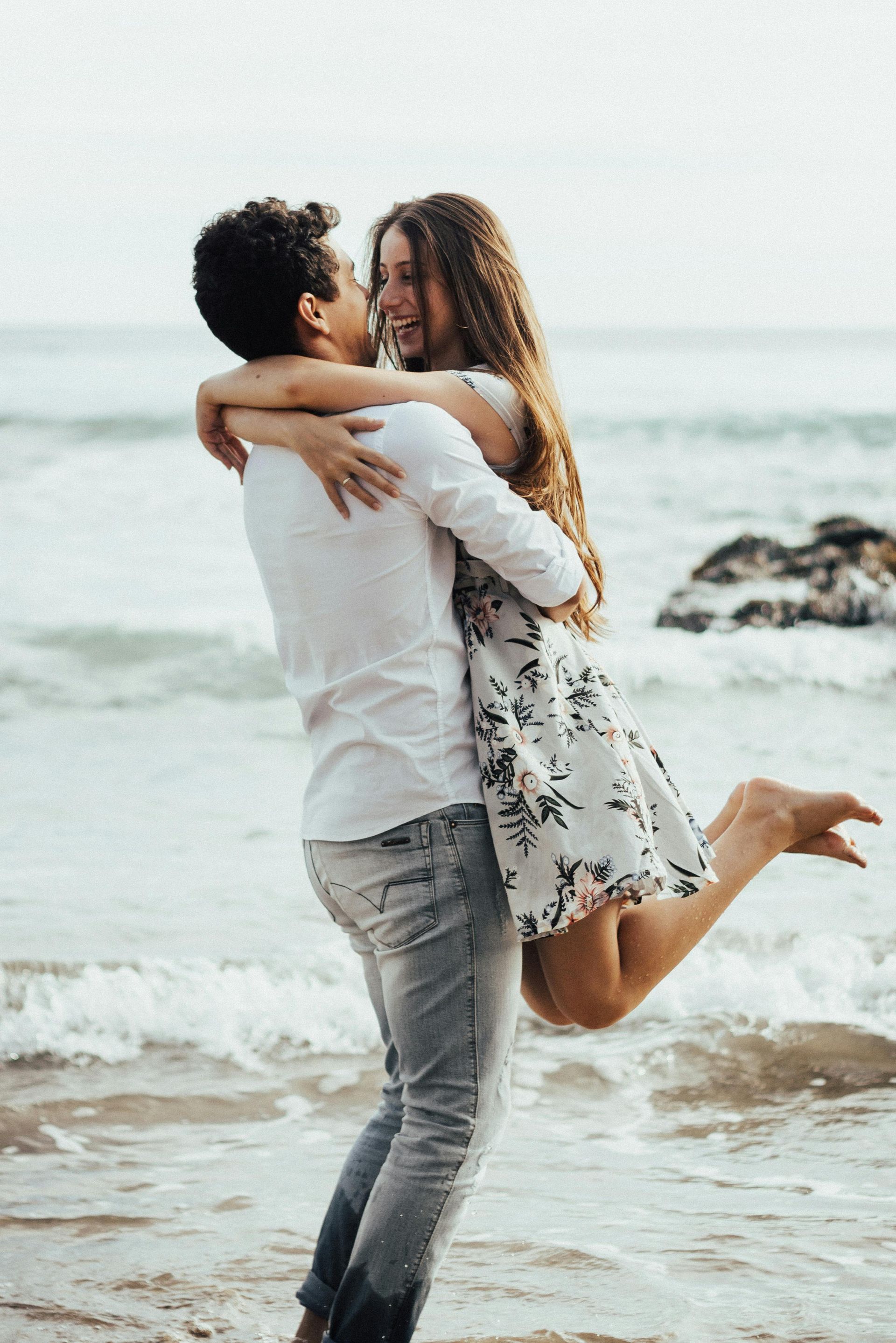 Two people are holding hands in front of a body of water — Essy K Counselling And Wellness Hub In Croudace Bay NSW