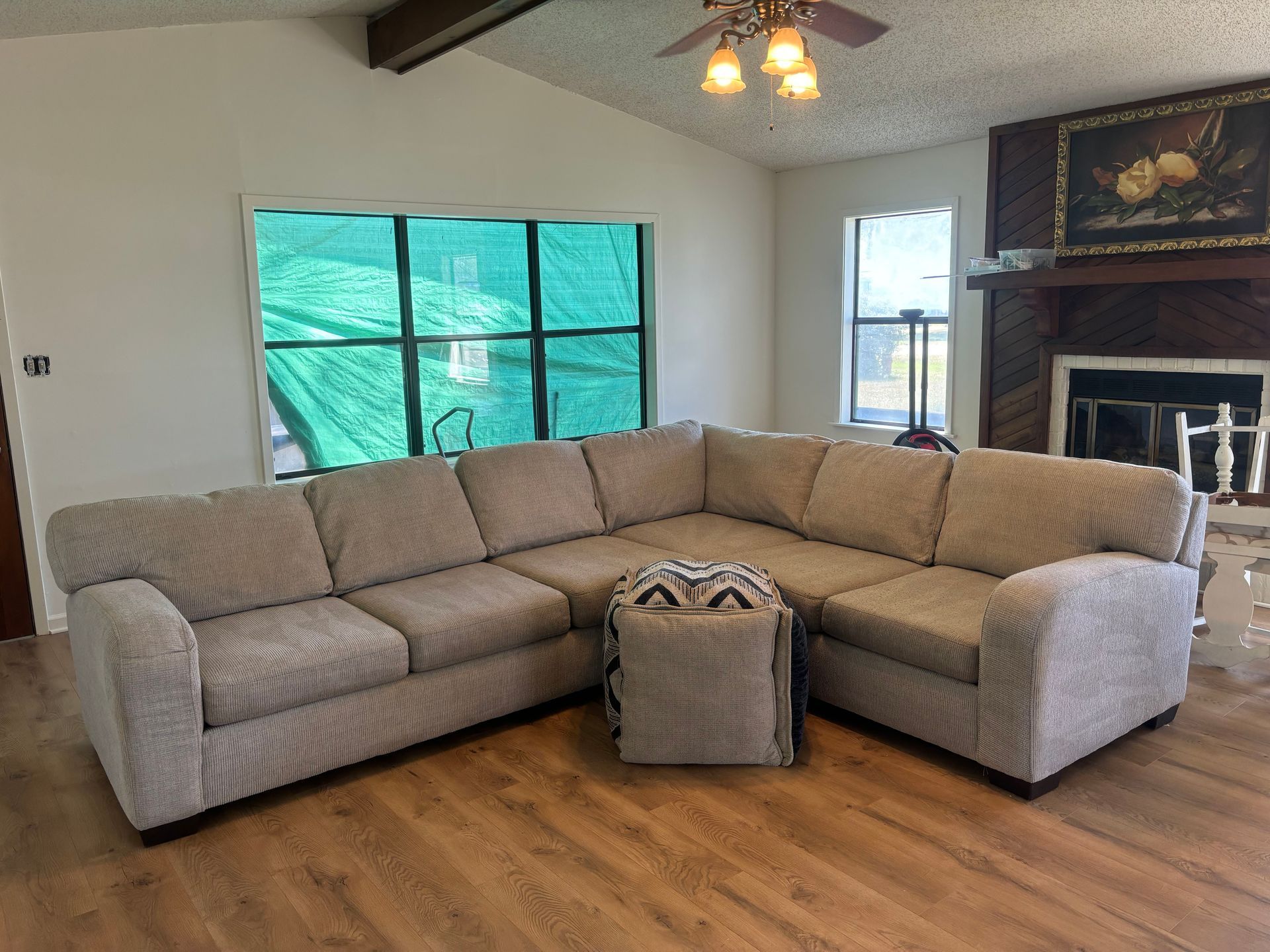 A living room with a large sectional couch and a fireplace.
