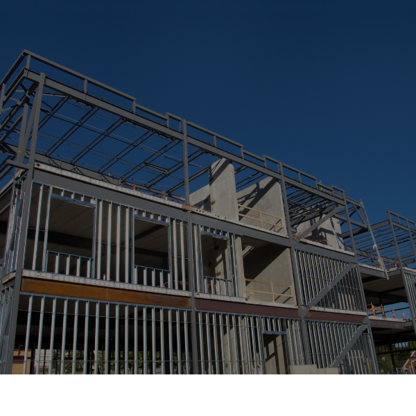 Modern building under construction with steel framing against a clear blue sky