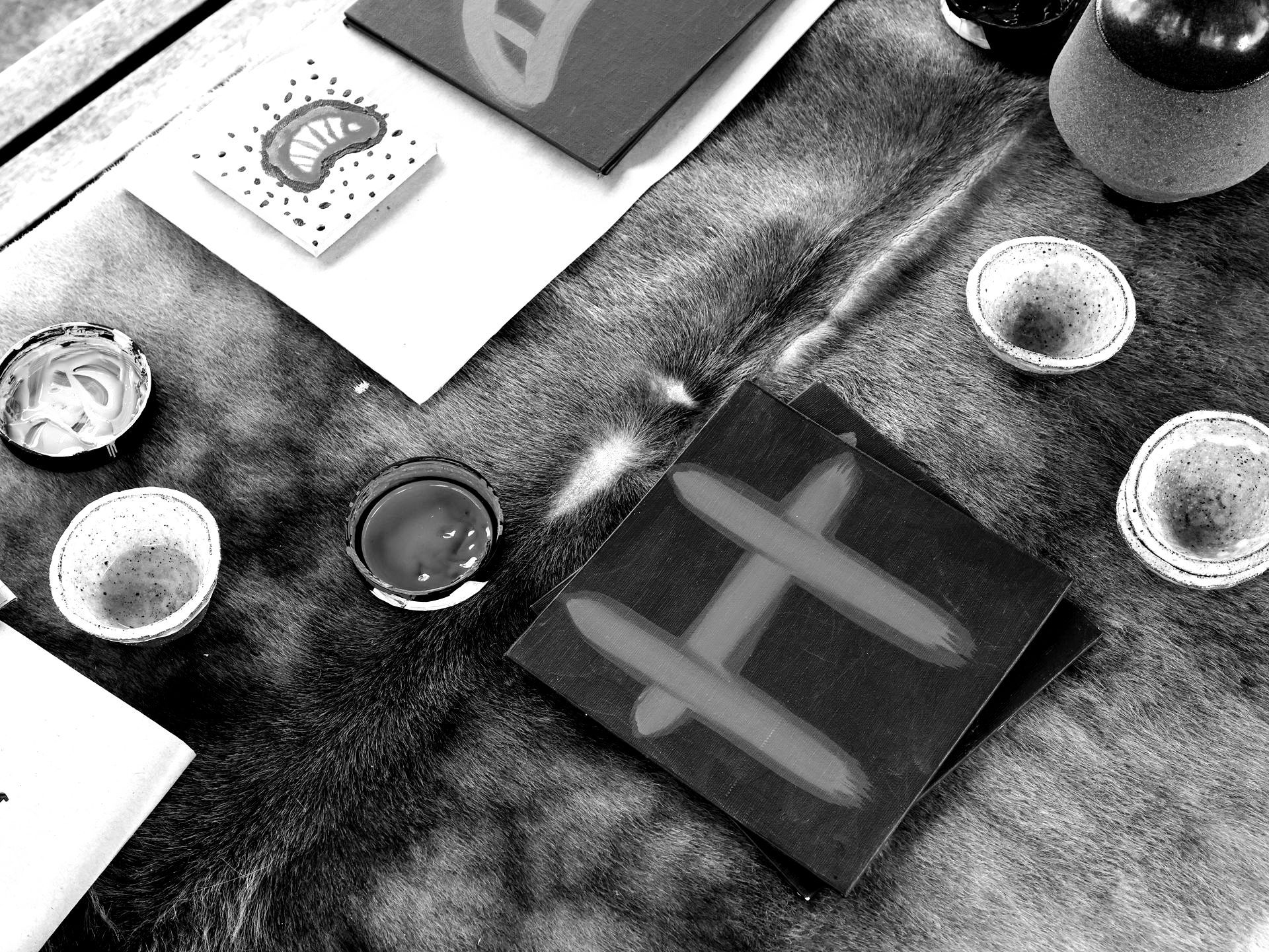 A black and white photo of a table with a piece of paper with the letter h on it