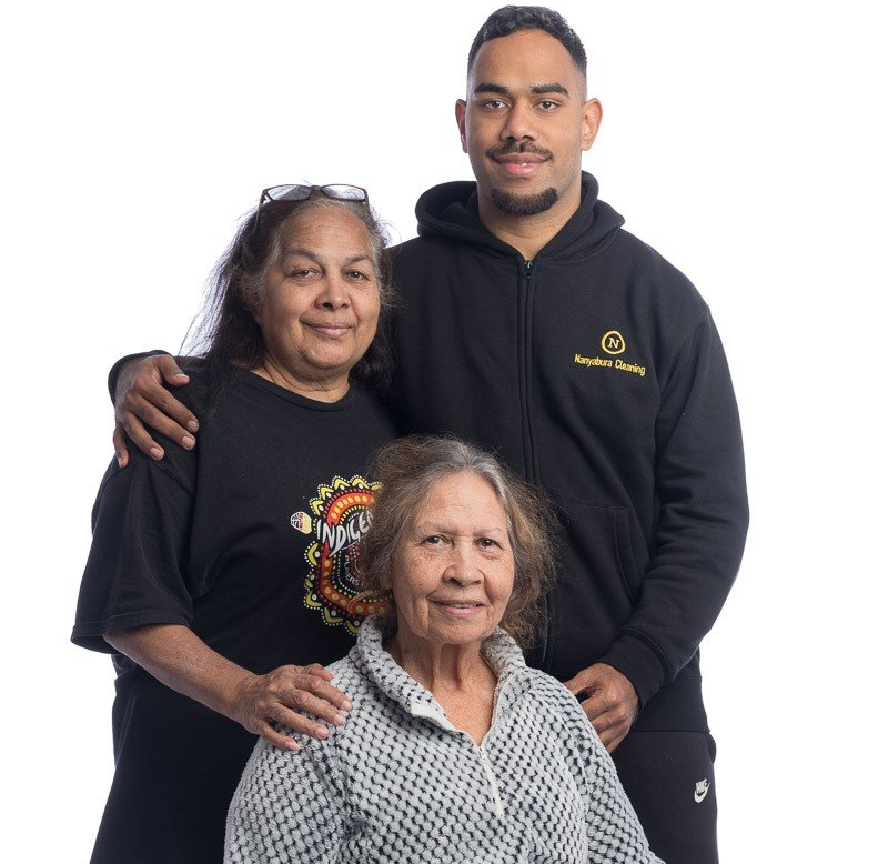 A man in a black hoodie stands between two women