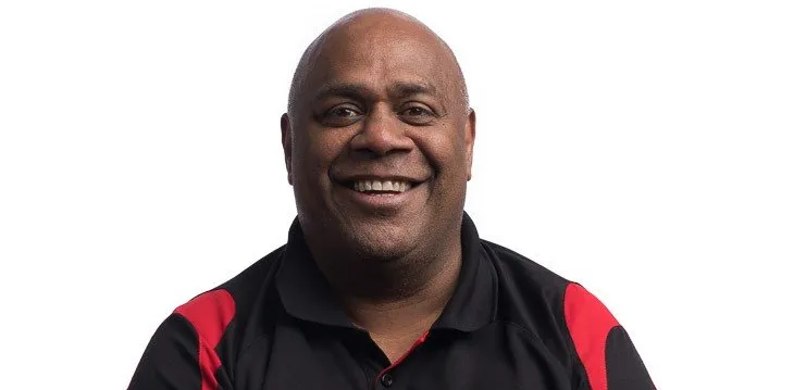 A man in a black and red shirt is smiling for the camera.