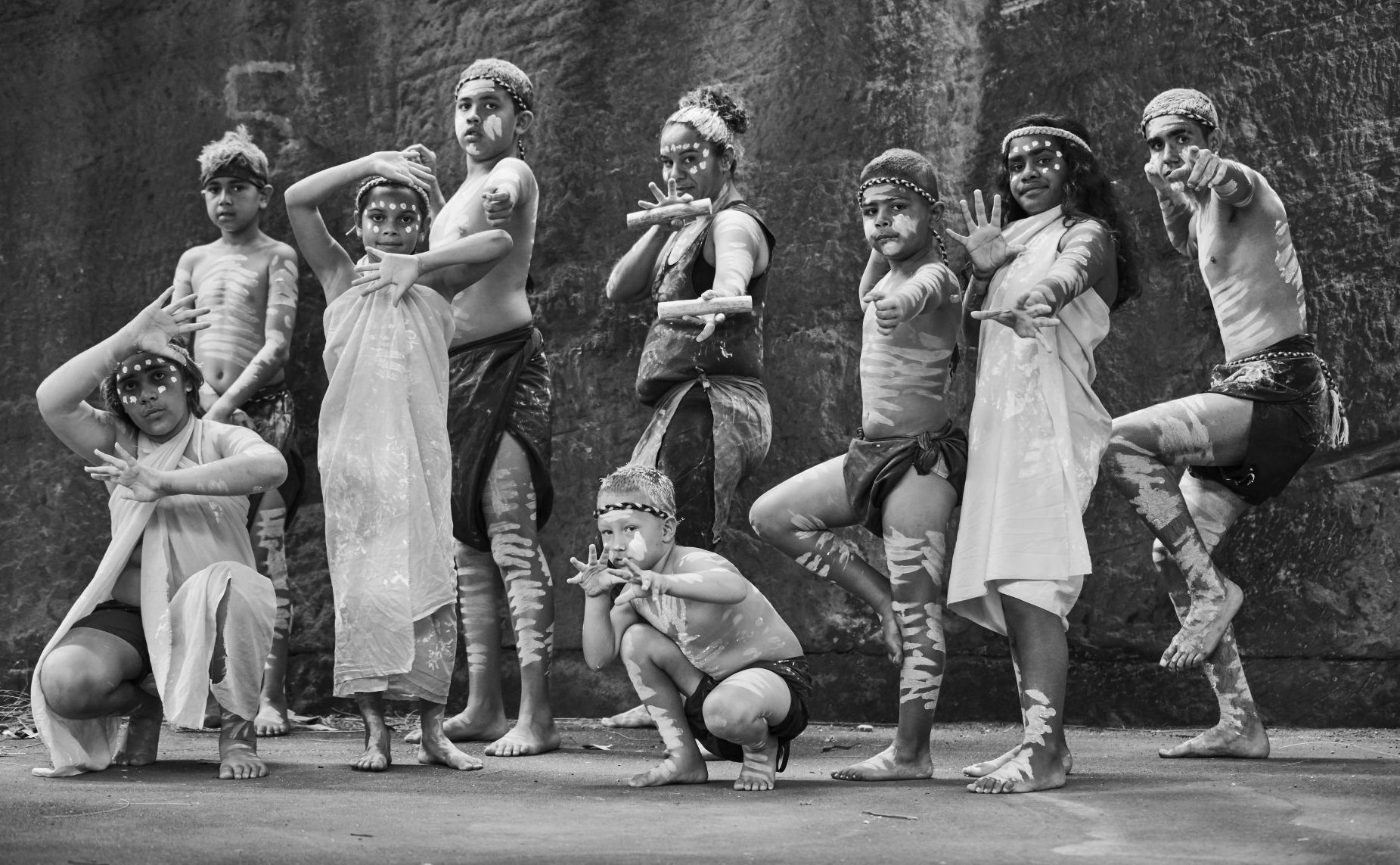 A black and white photo of a man with a beard wearing a hoodie.