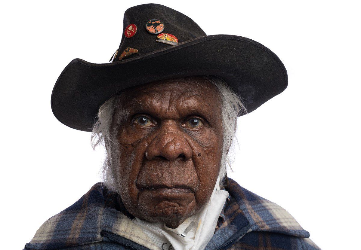A man wearing a cowboy hat and a plaid jacket