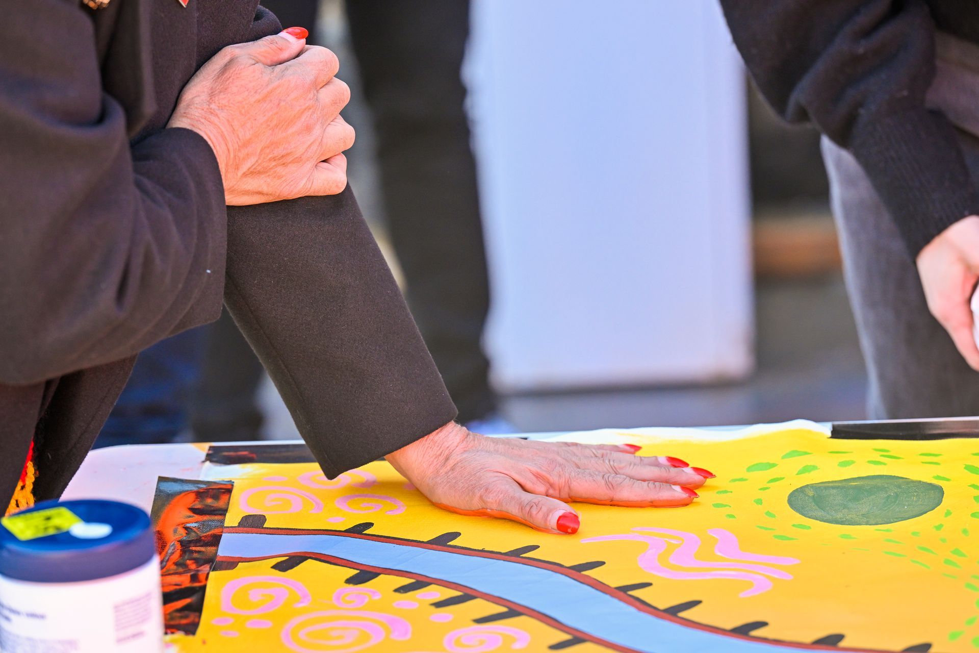 A woman is touching a painting Aboriginal Artwork | Tribal Warrior Talent | Cultural Awareness 