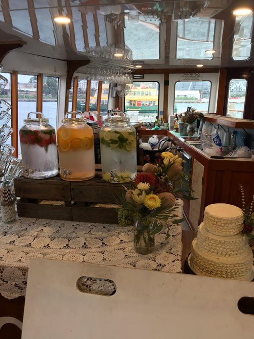 A table with a cake and jars of drinks on it.