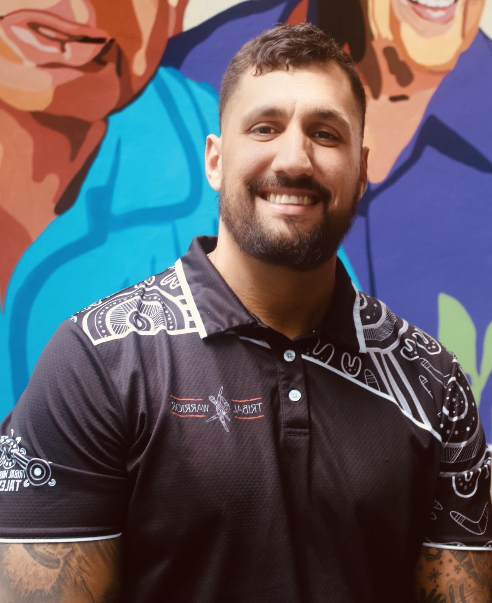 A man with a beard wearing a black polo shirt