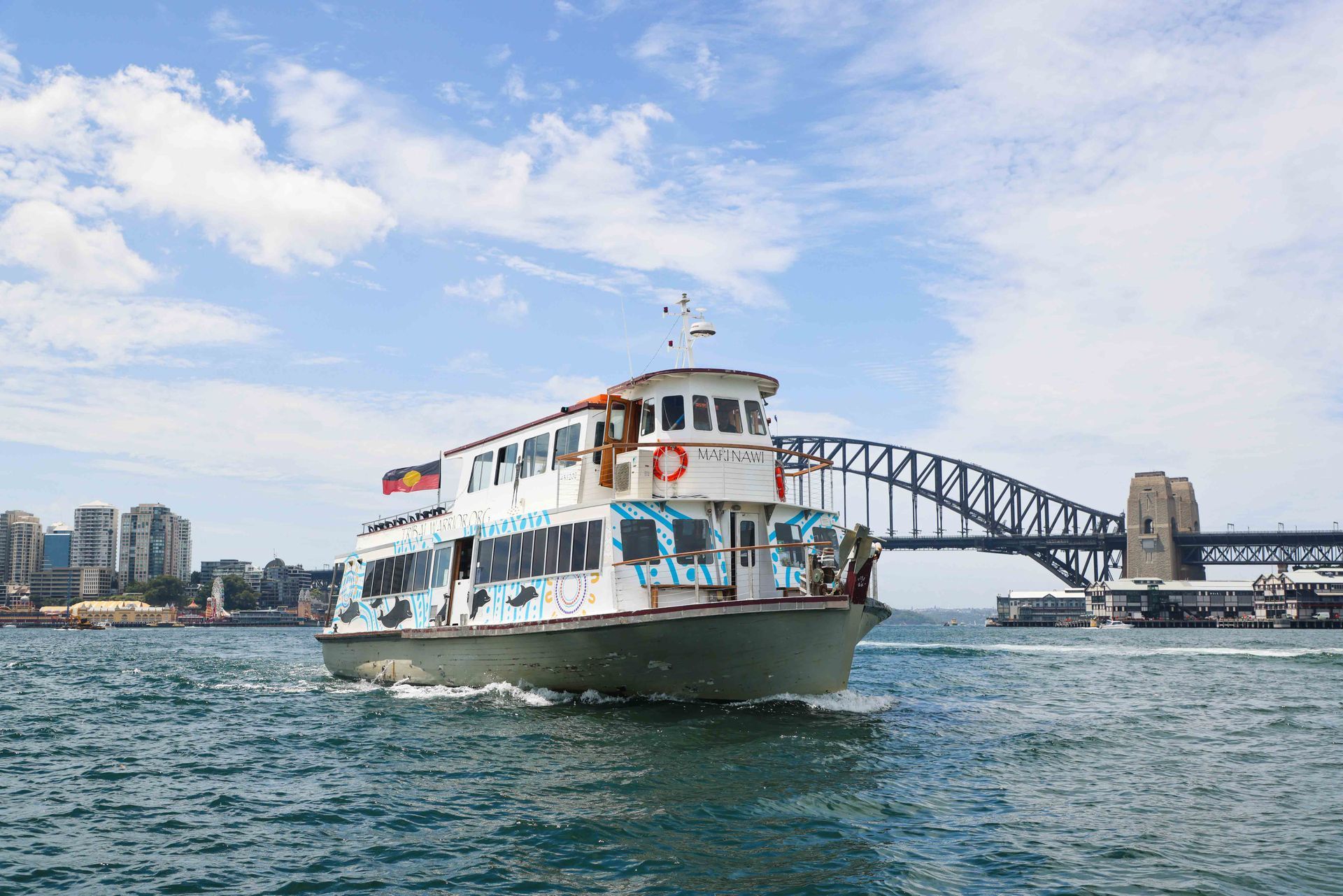 A large boat is docked at a dock in a city.