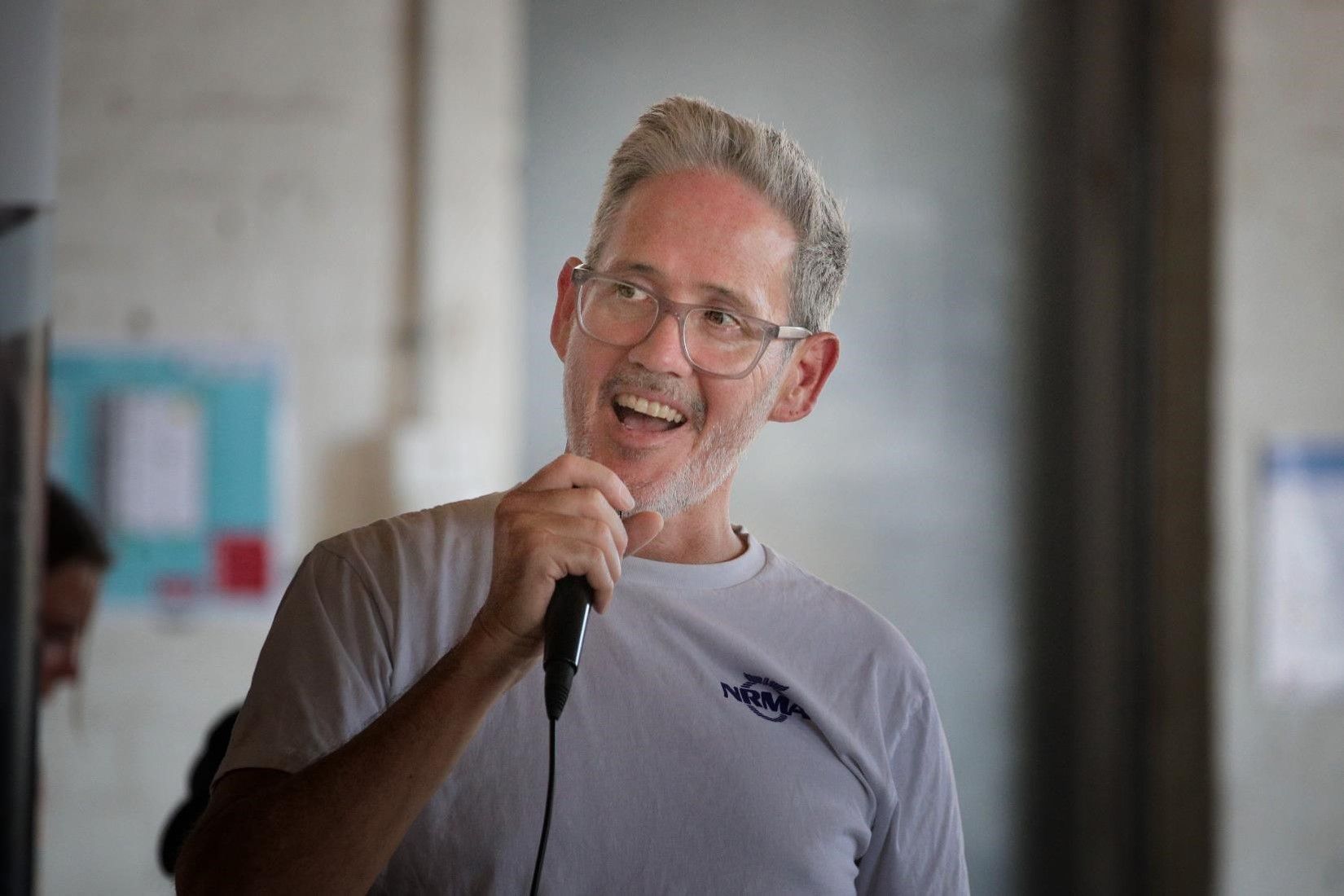 A man is holding a microphone in his hand and smiling.