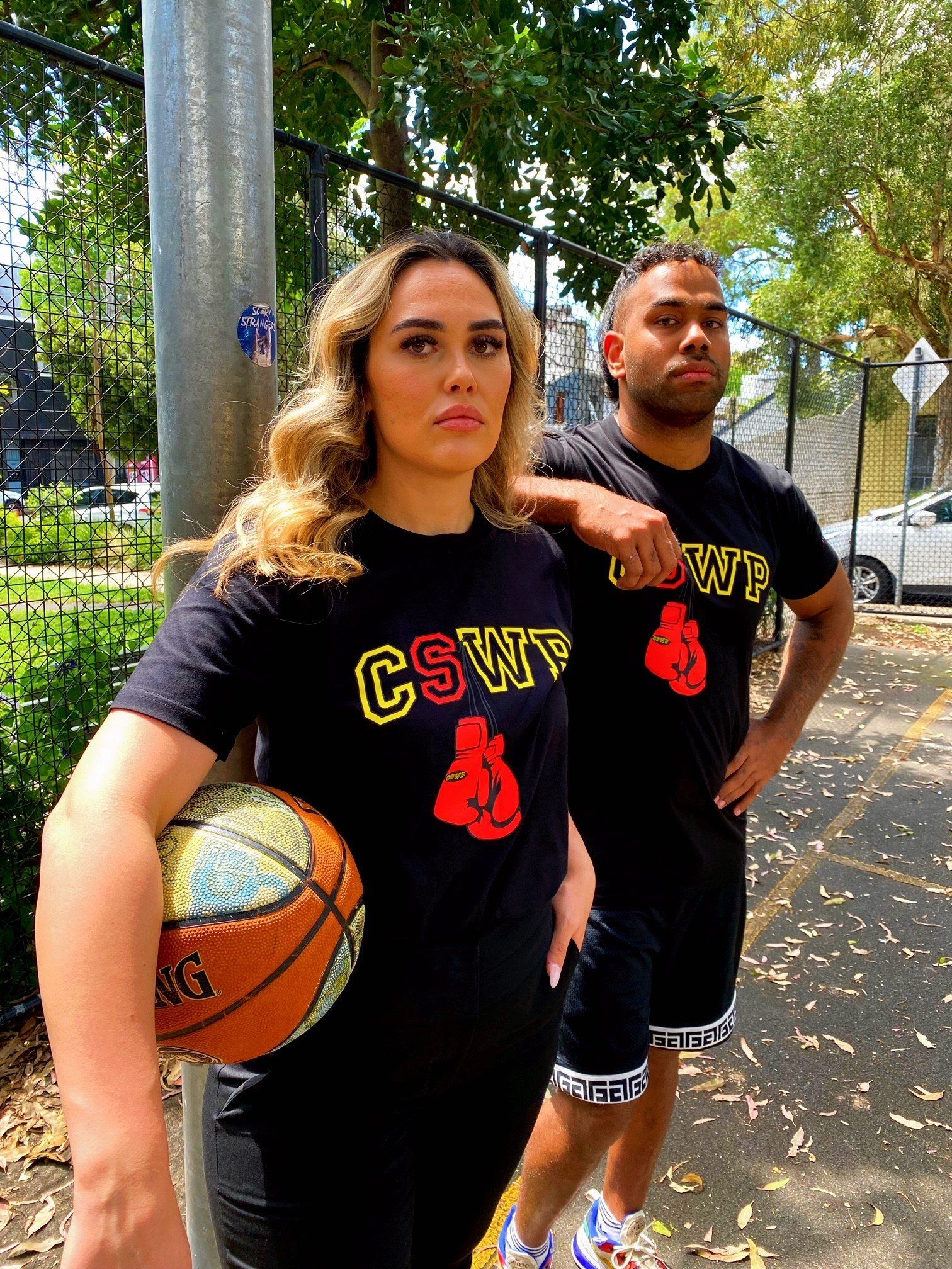 A man and a woman are standing next to each other holding a basketball.