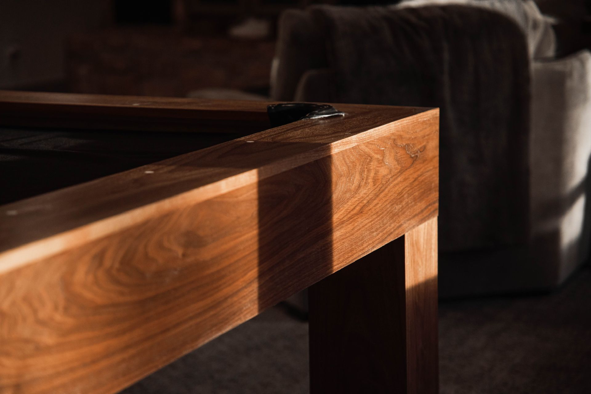 A wooden table is sitting in a living room next to a couch.