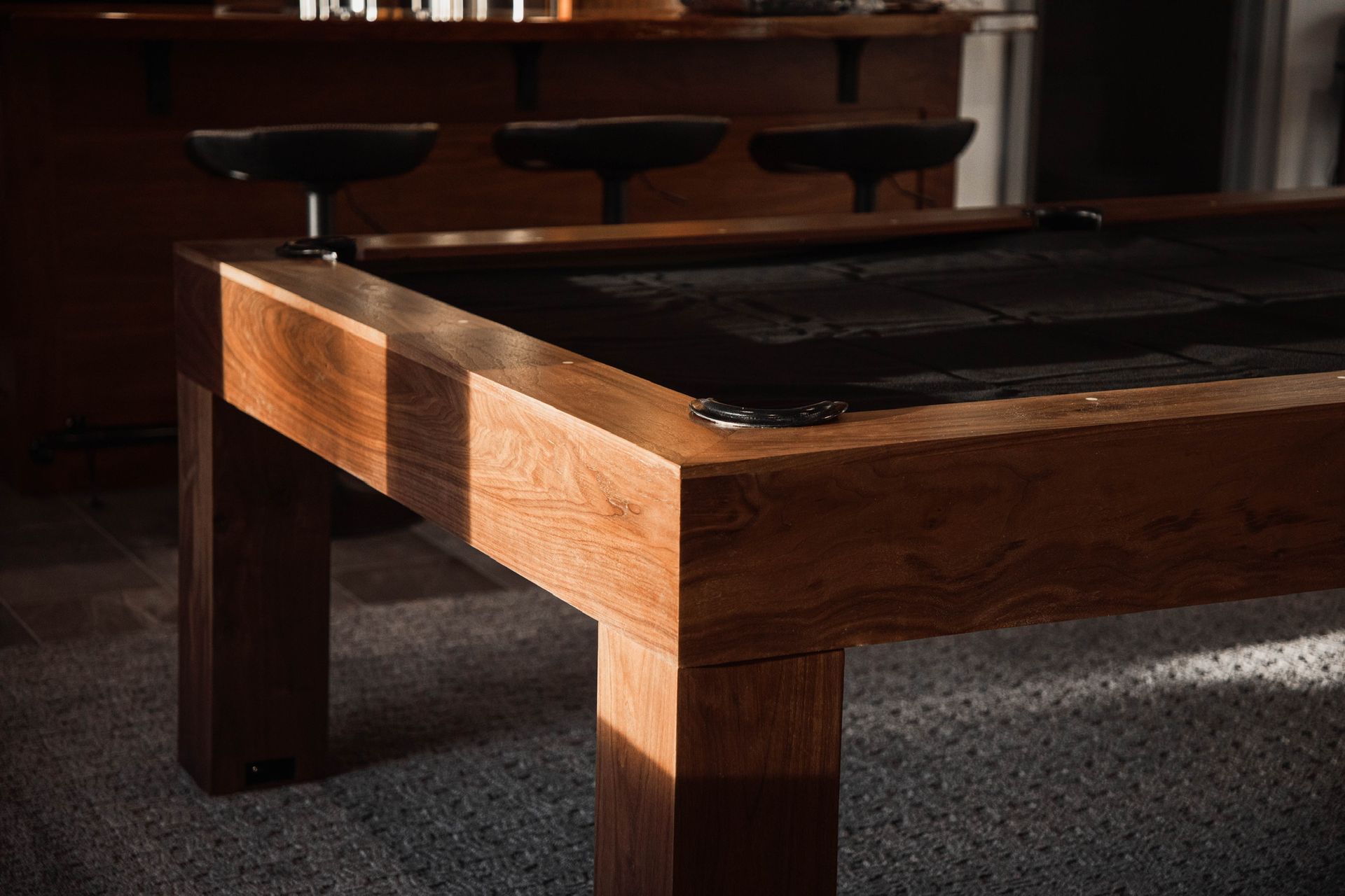 A close up of a piece of wood on a table with tools in the background.