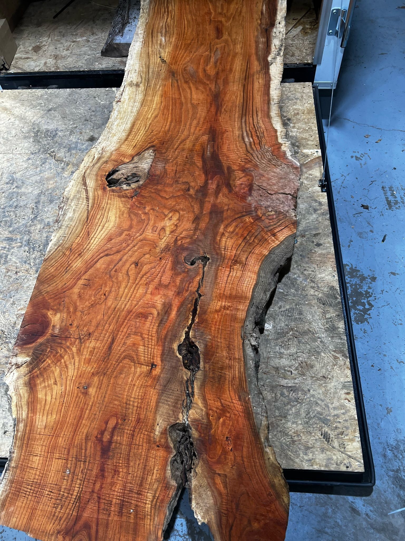 A large piece of wood is sitting on top of a pallet.