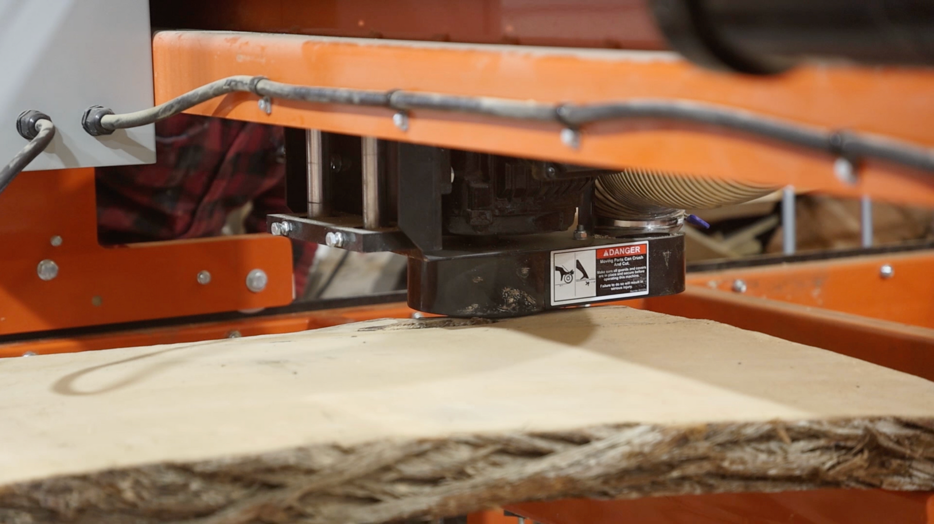 A machine is cutting a piece of wood on a table.