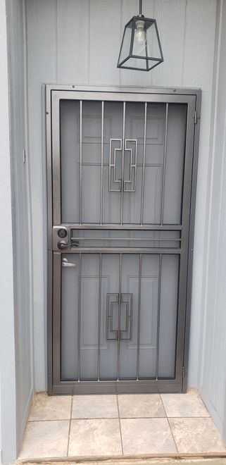 Steel security door with decorative grid and a hanging light.