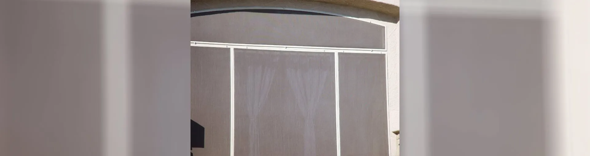 Wooden door with vertical panels, and overhead molding.