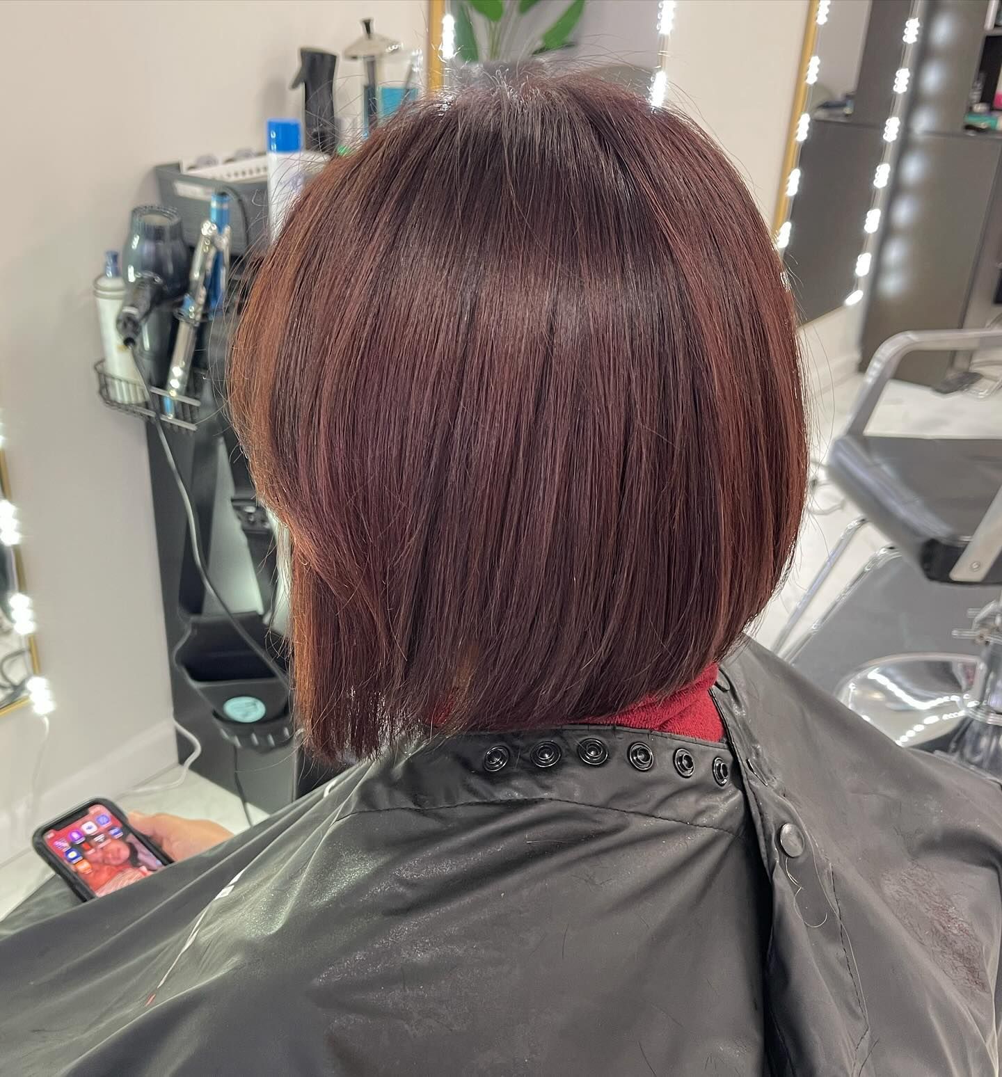 A woman is getting her hair cut in a salon.