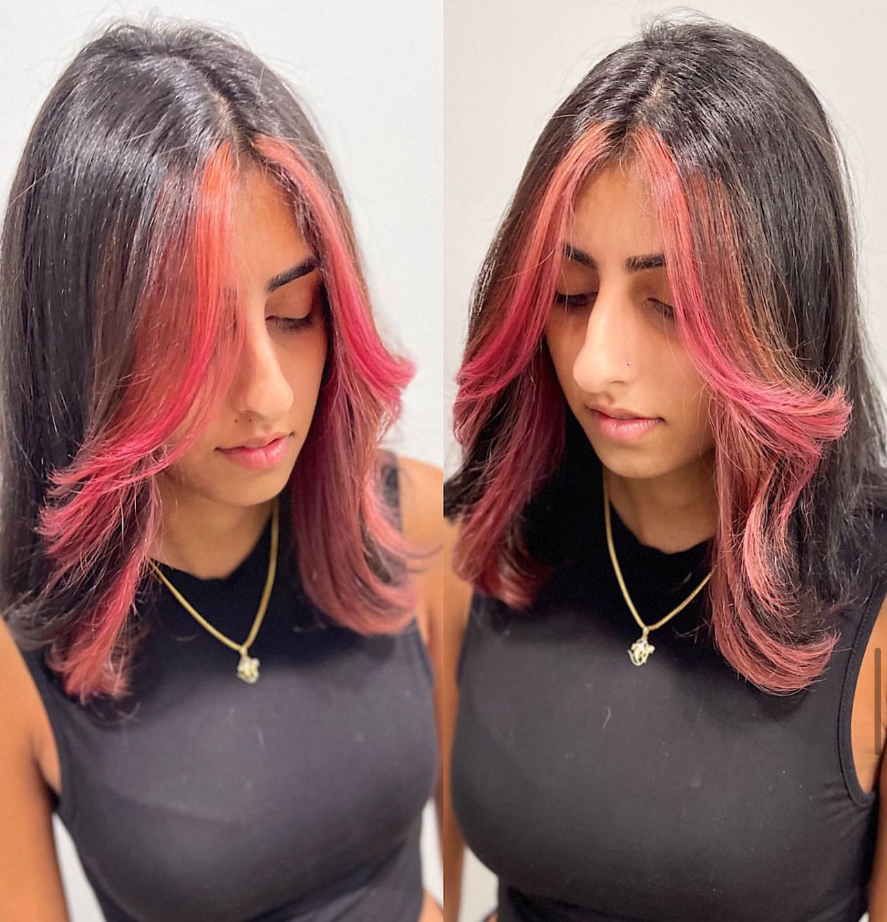 A woman with black hair and red highlights is wearing a black tank top