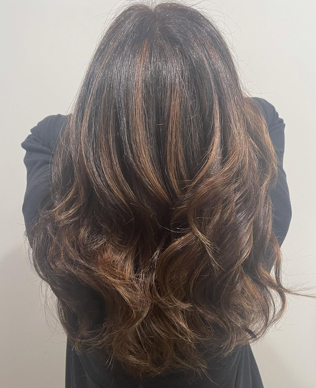 The back of a woman 's head with long brown hair.