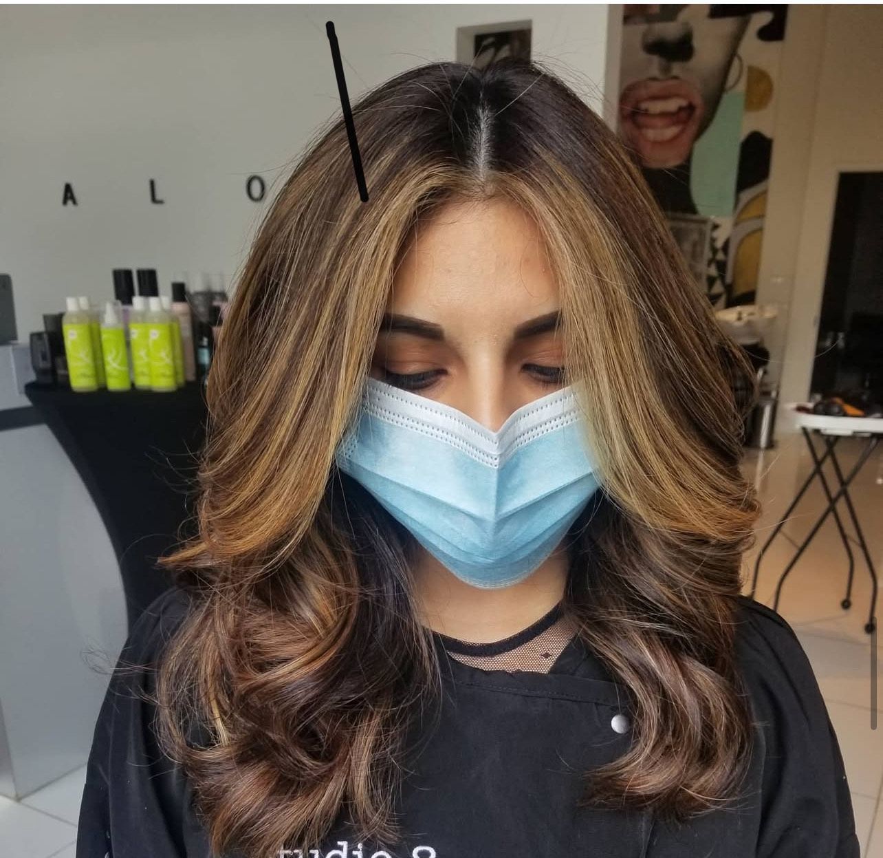 A woman wearing a face mask in a salon