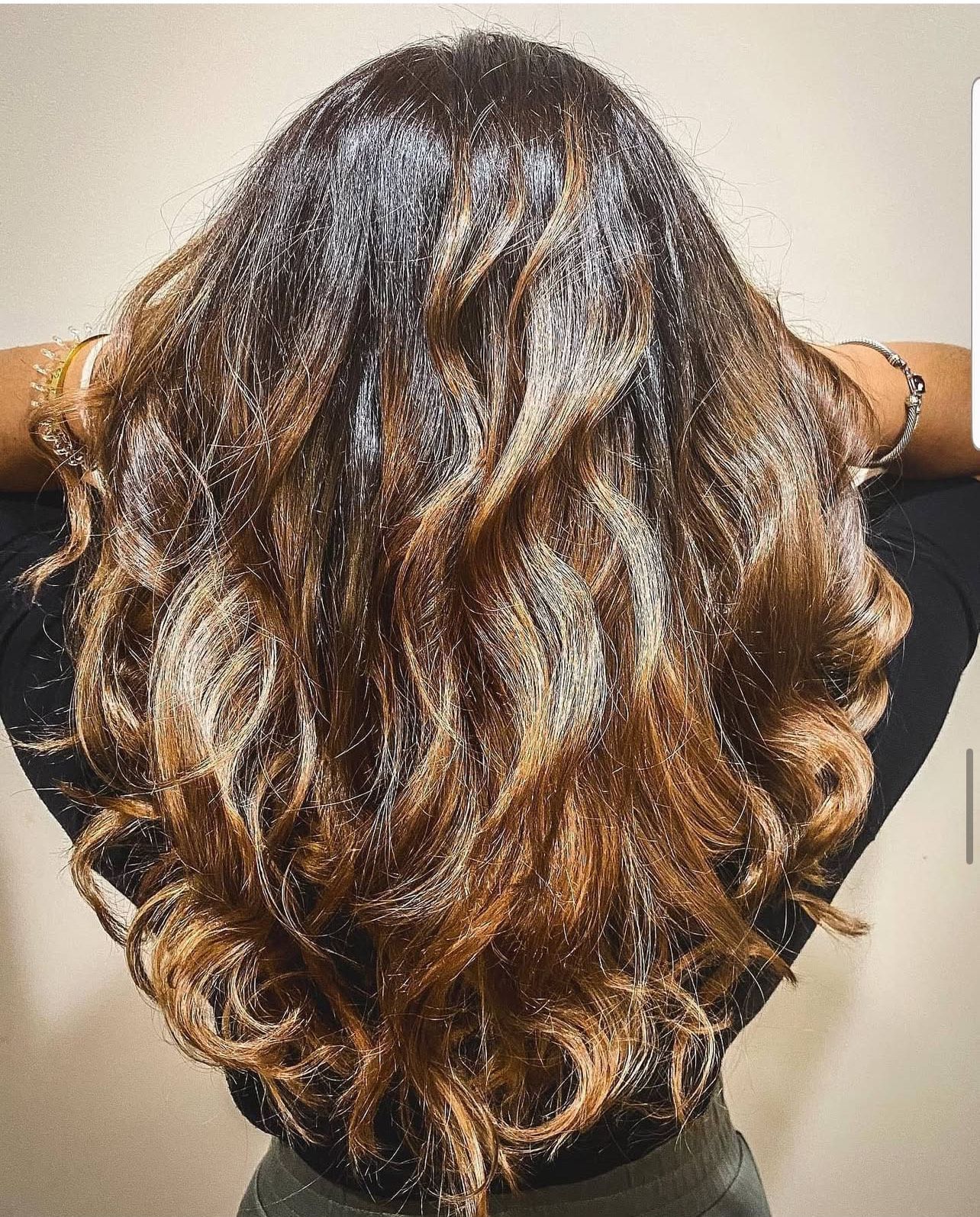 The back of a woman 's head with long brown hair.