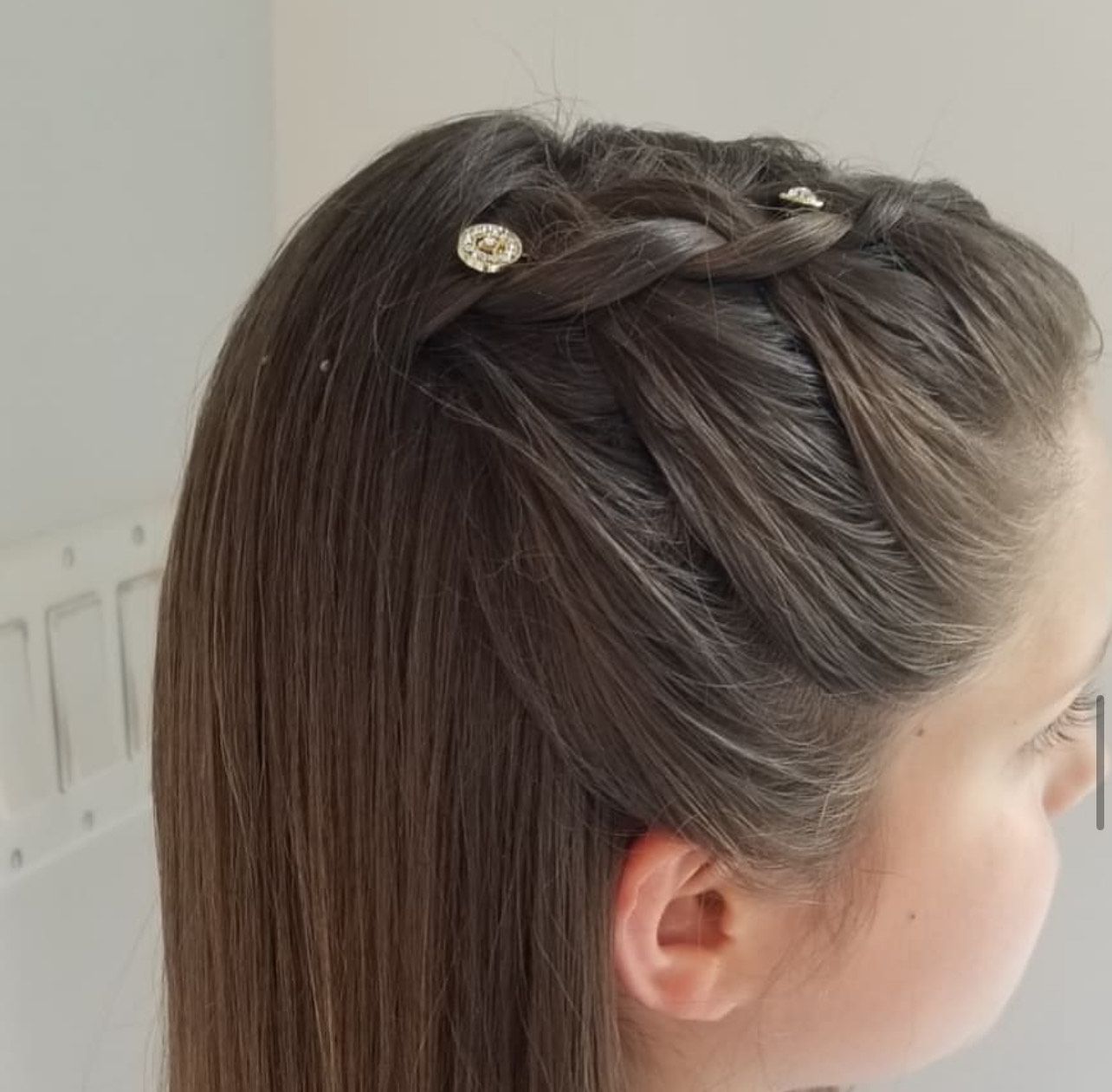 A close up of a girl 's hair with a braid.