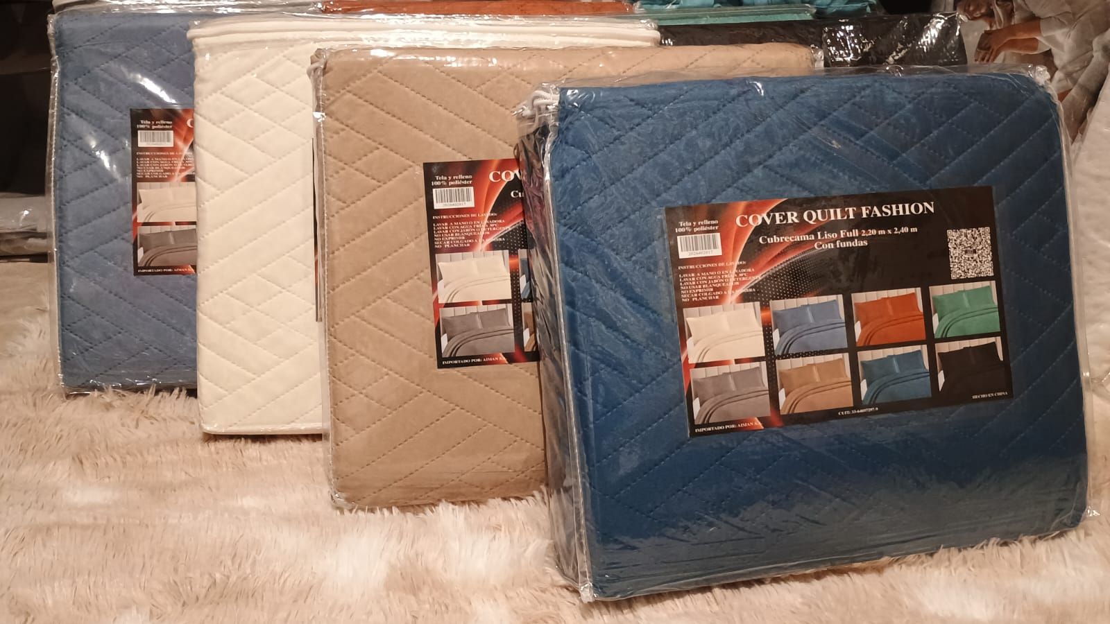 Almohada y cojín acolchados de color gris sobre una alfombra peluda con una tarjeta de muestra de color en el frente.