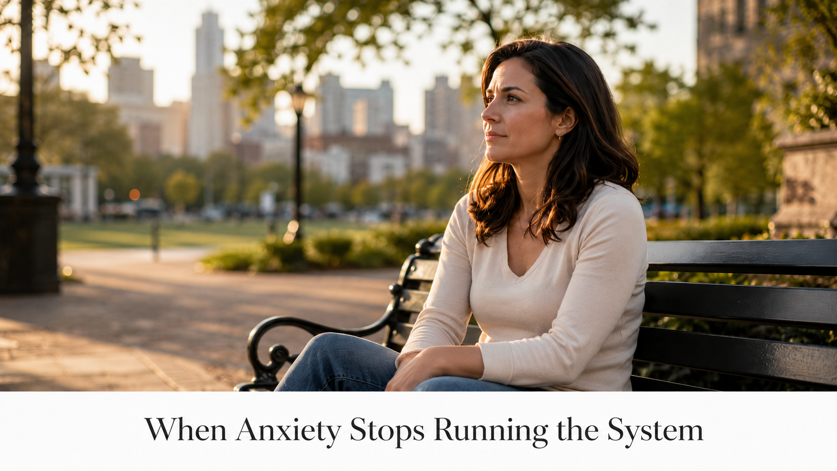 Woman sitting thoughtfully on a city park bench, representing hypnosis for anxiety in New York, Miam
