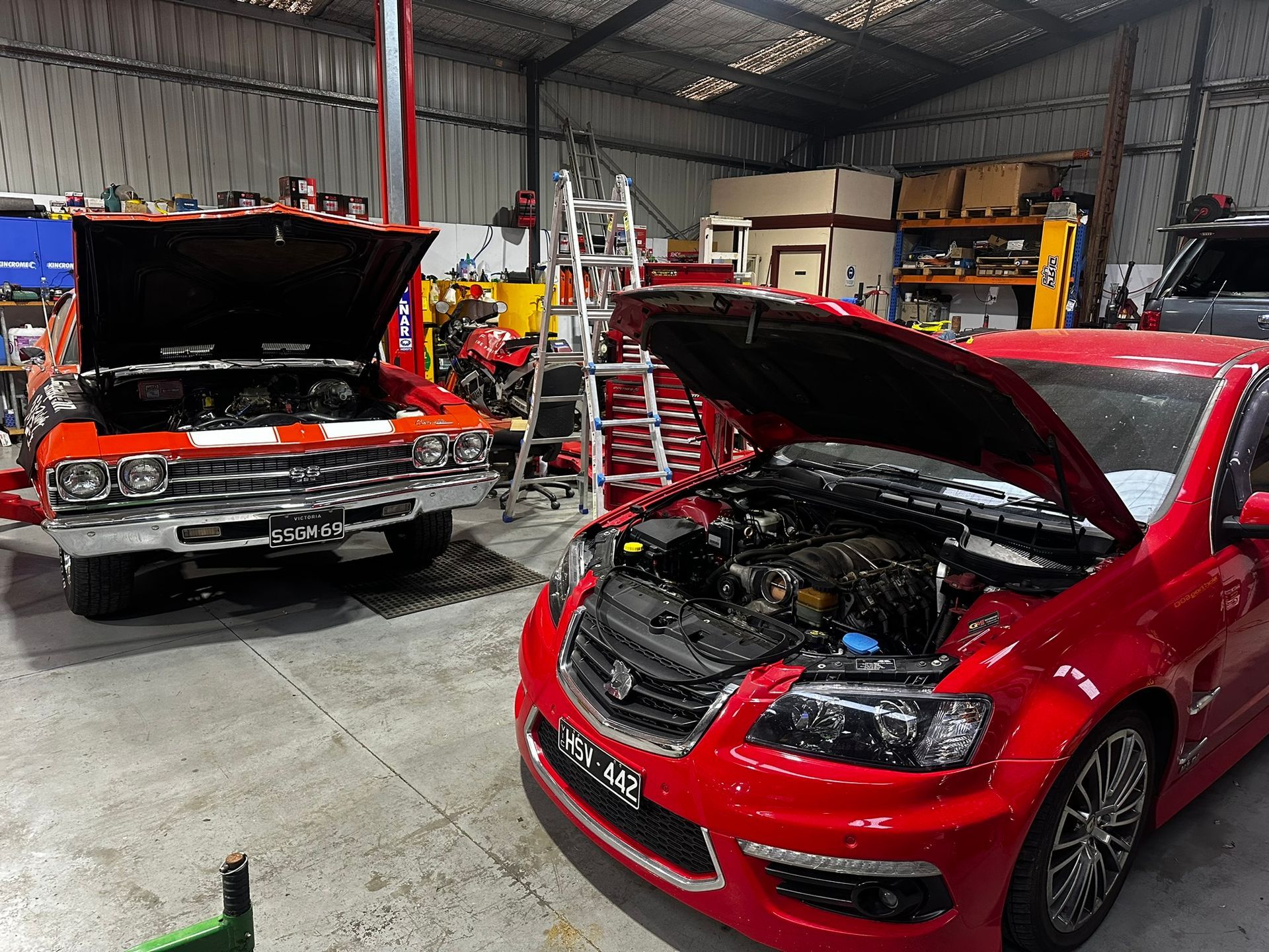 2 Red Cars With Their Hoods Open — Marsh Mechanics and Auto Electrical in Maddingley, VIC