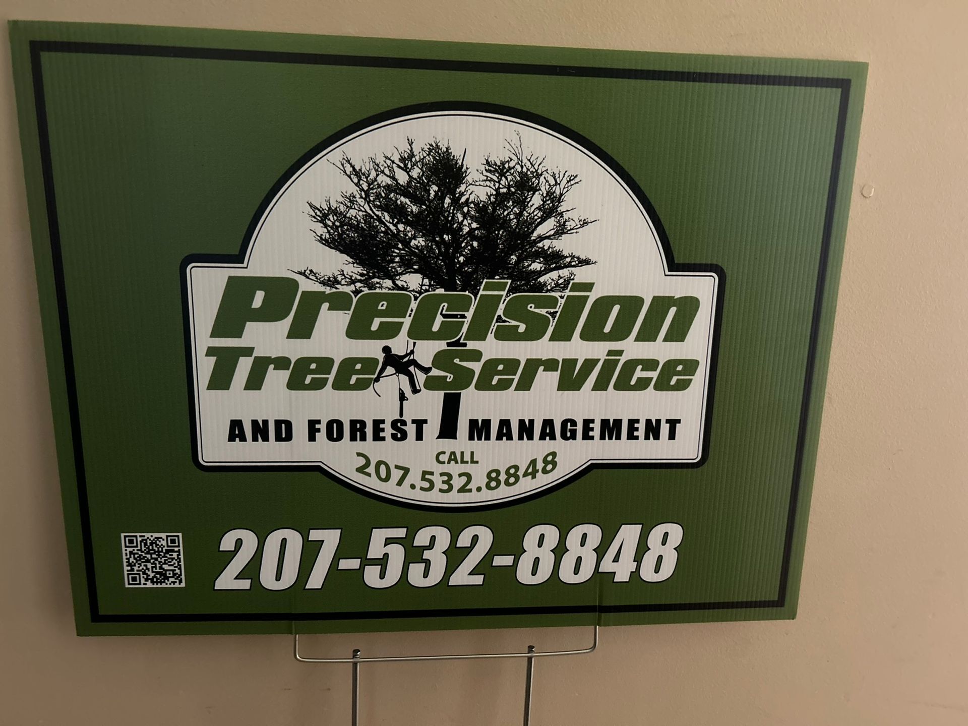 A sign for precision tree service and forest management