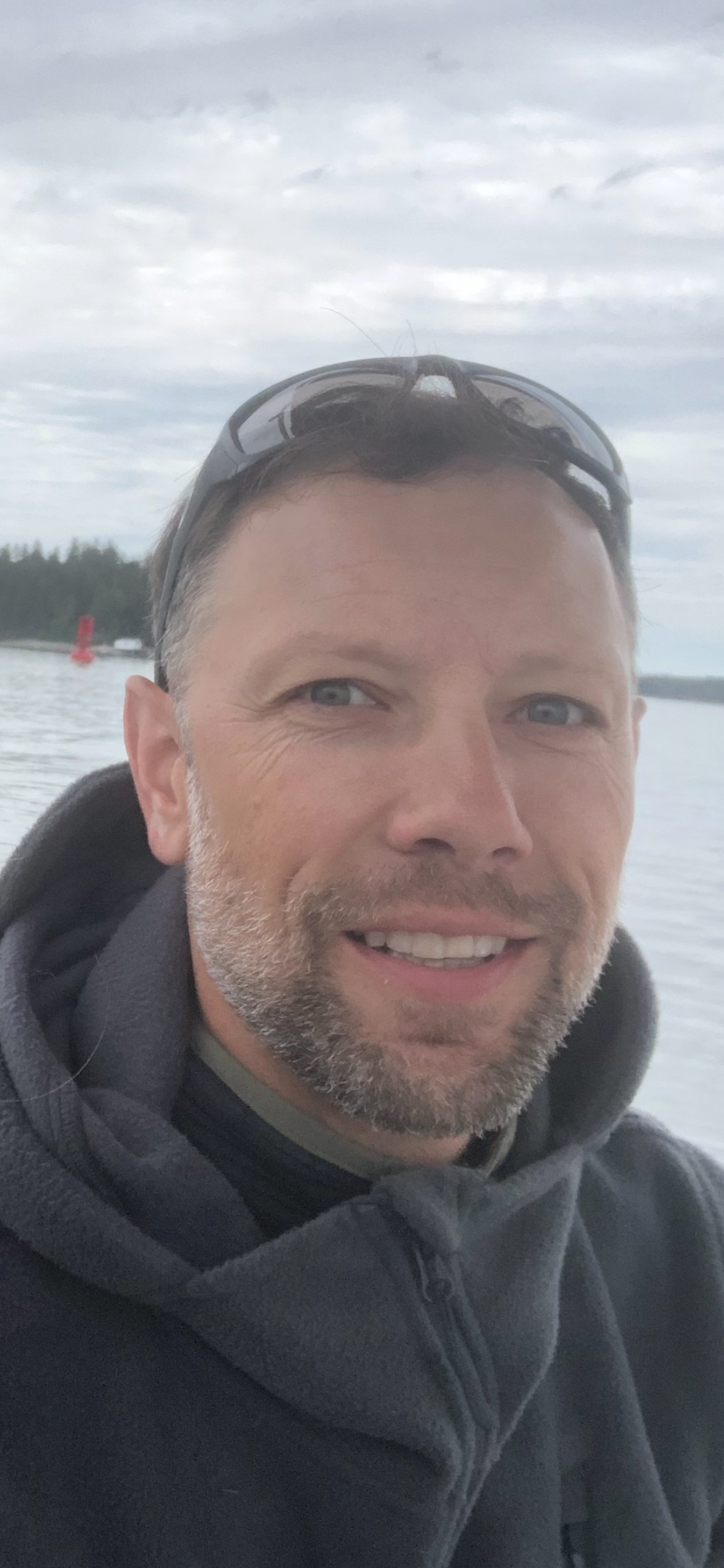 A man with a beard and sunglasses is smiling for the camera.