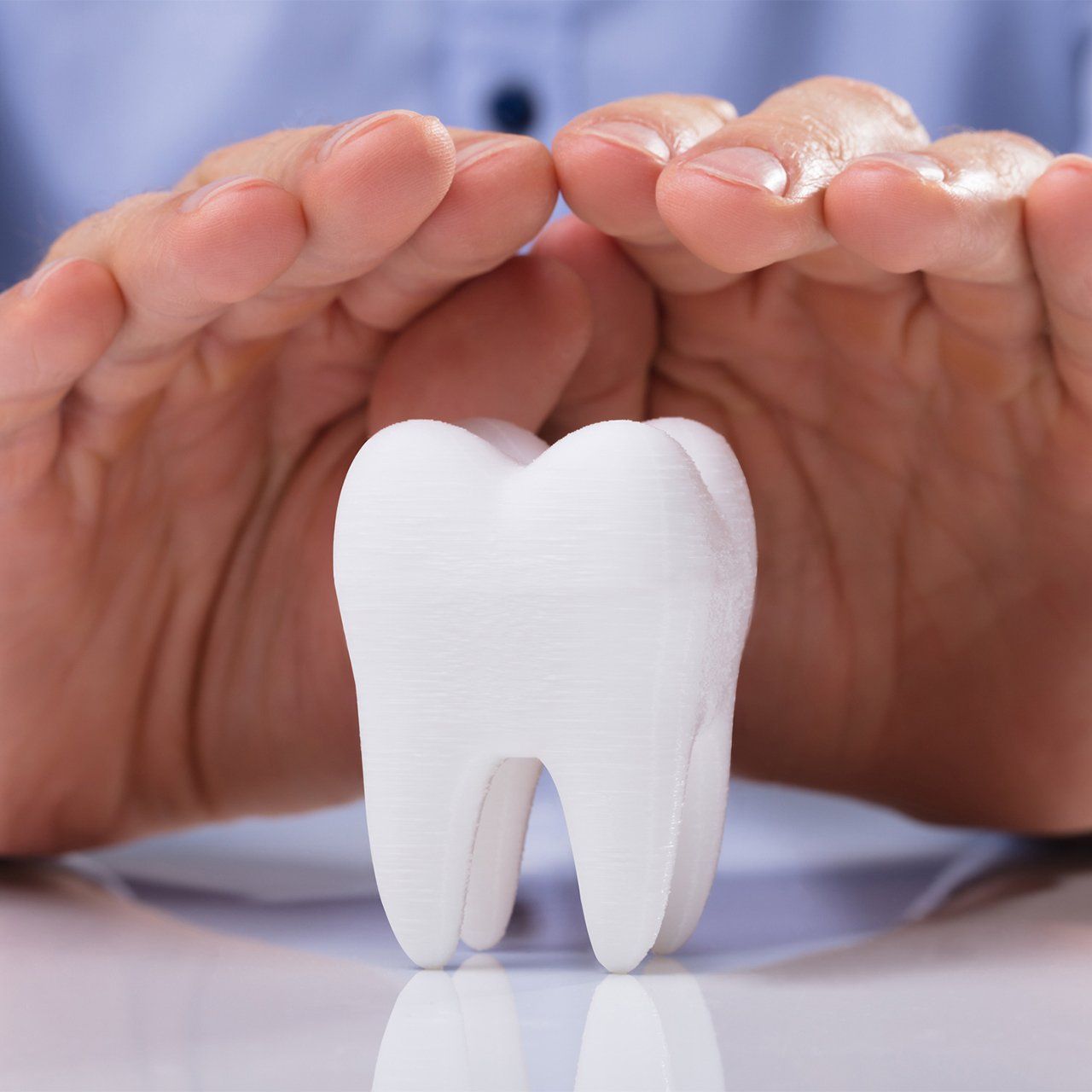 Man's Hand Protecting White Tooth — Frankfort, IL — Brookside Dental Care Man's Hand Protecting White Tooth — Frankfort, IL — Brookside Dental Care