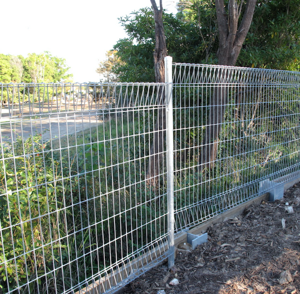 A wire fence with trees in the background