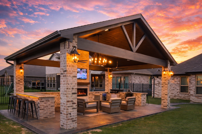 Bathroom with gold-framed glass shower, double vanity, large round mirror, and a freestanding tub.