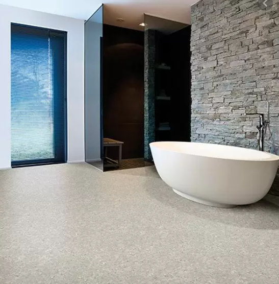 Een badkamer met een bad en een bakstenen muur