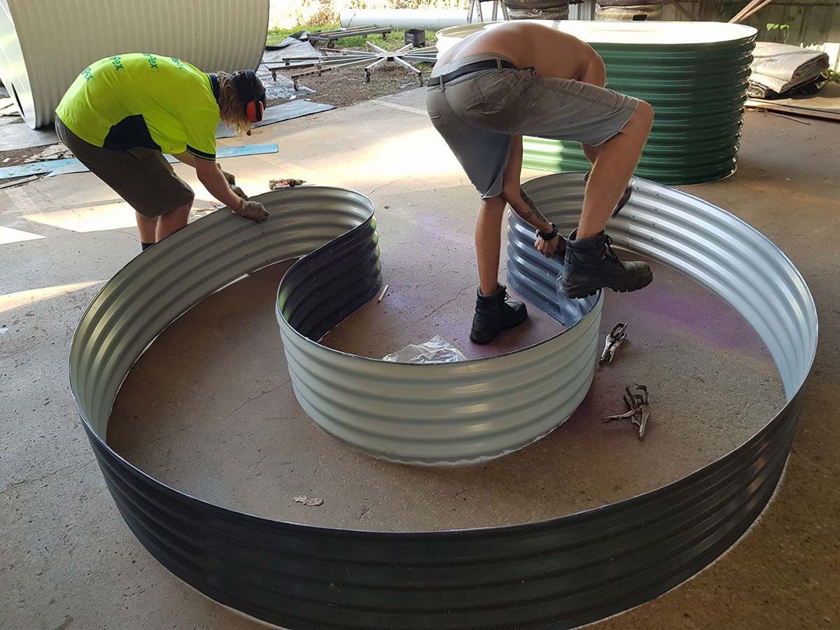 Two Men Are Working on a Large Metal Ring — Foley's Tanks in Nambour, QLD