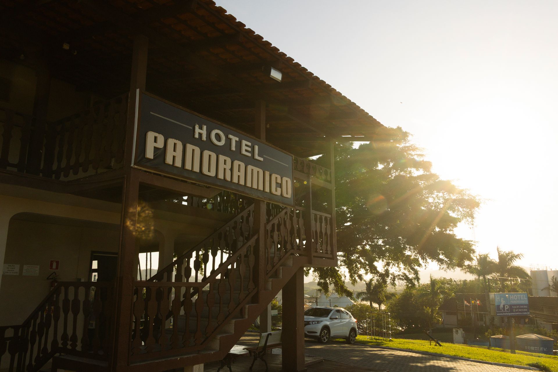 Placa do Hotel Panorâmico em um prédio de madeira, luz solar intensa.