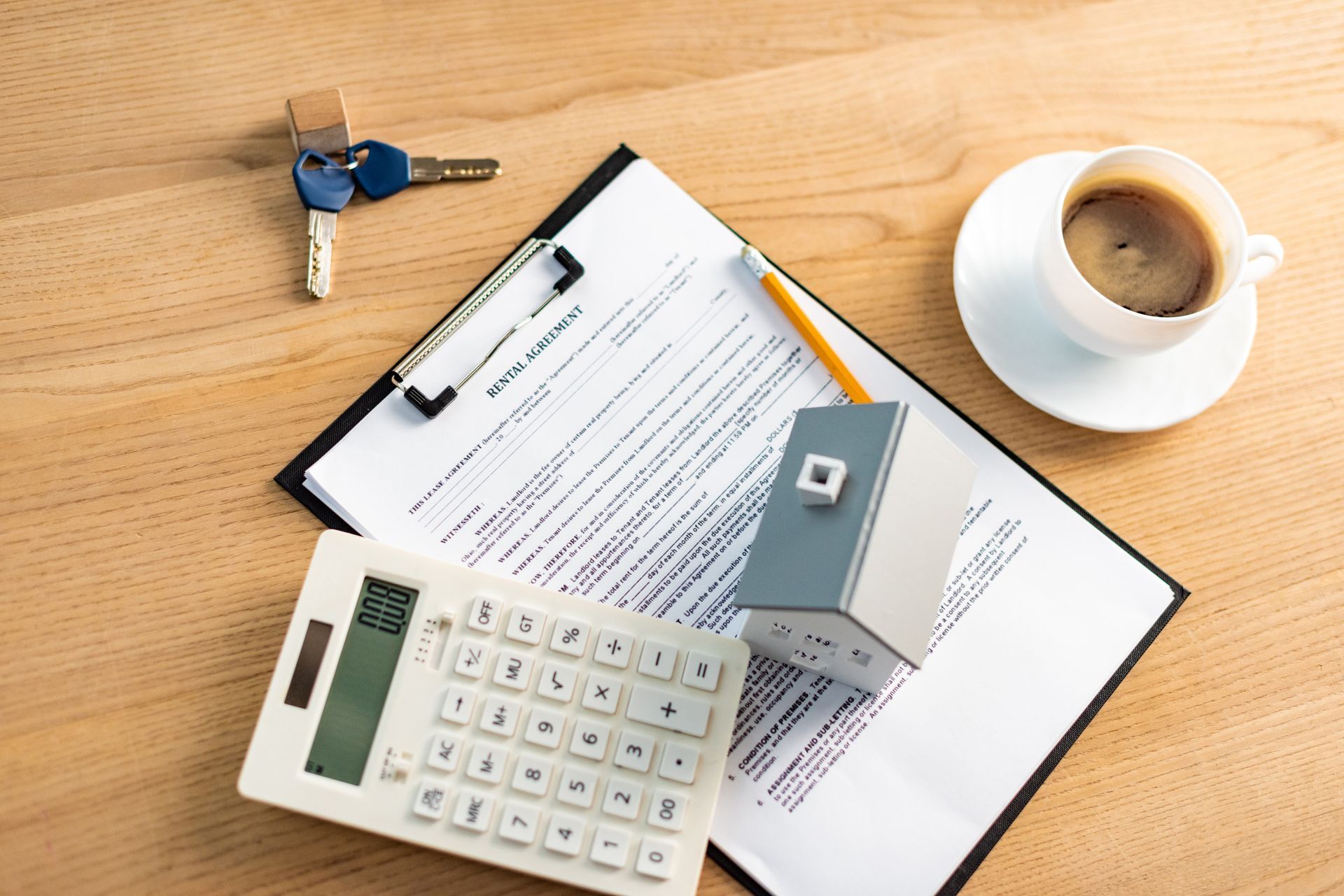 top view of cup of coffee near clipboard with rental agreement contract on table