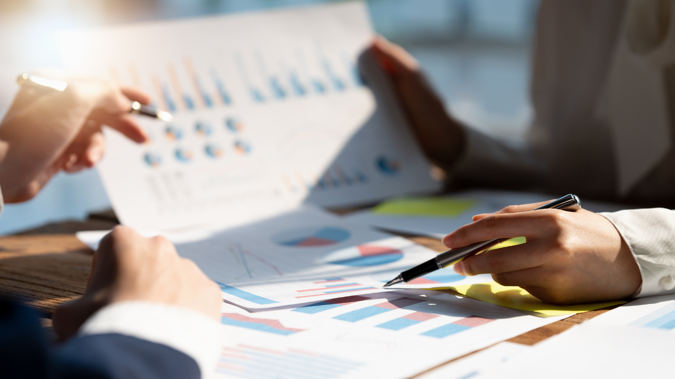 A group of people are sitting at a table looking at a piece of paper.