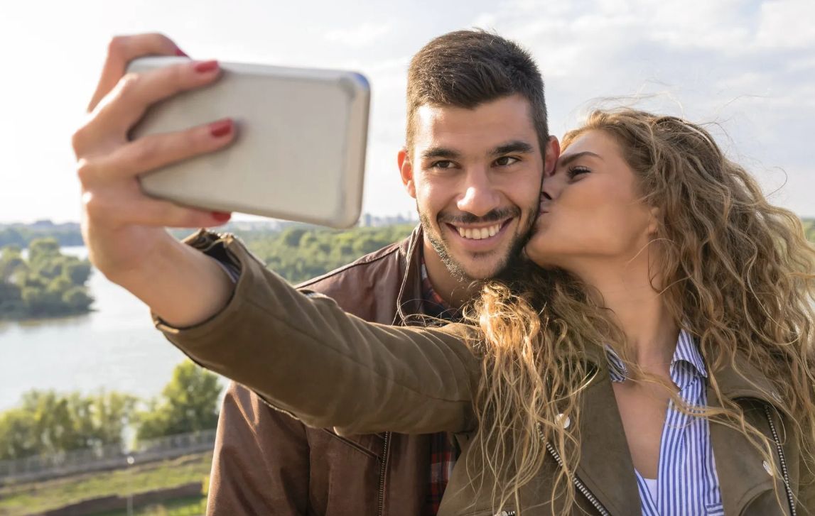 a happy couple takes a selfie during their engagement