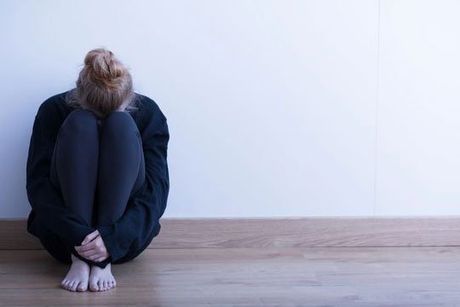 Depressed woman curled up indicating depression and anxiety counseling services
