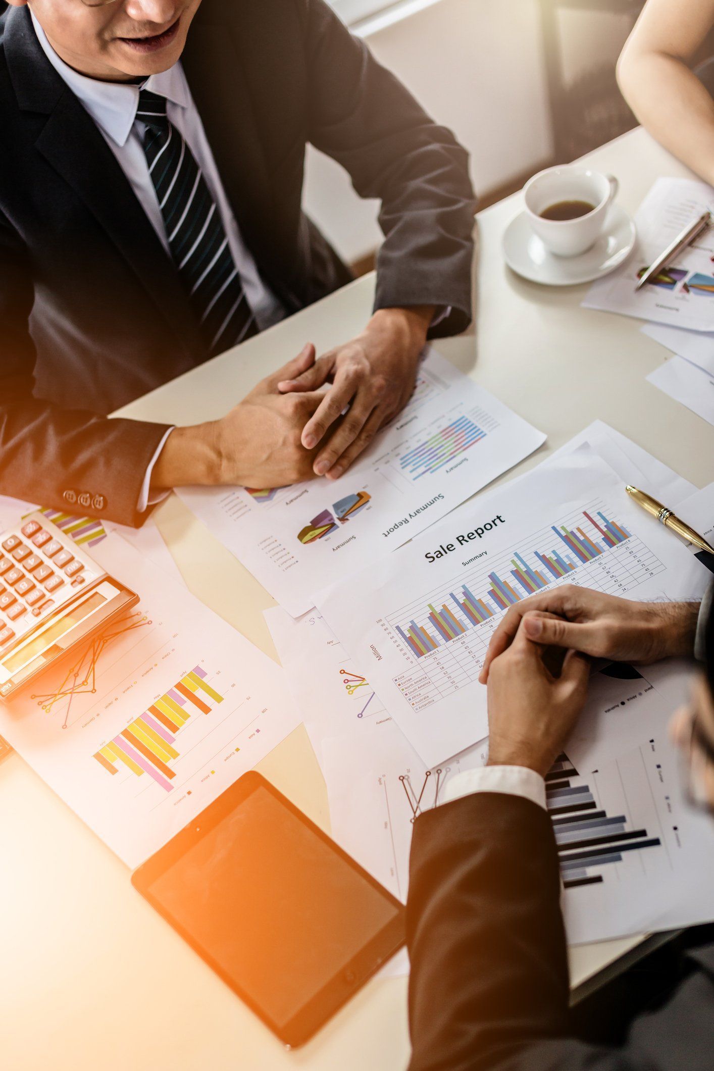 two businessmen sitting on table with financial report documents on desk