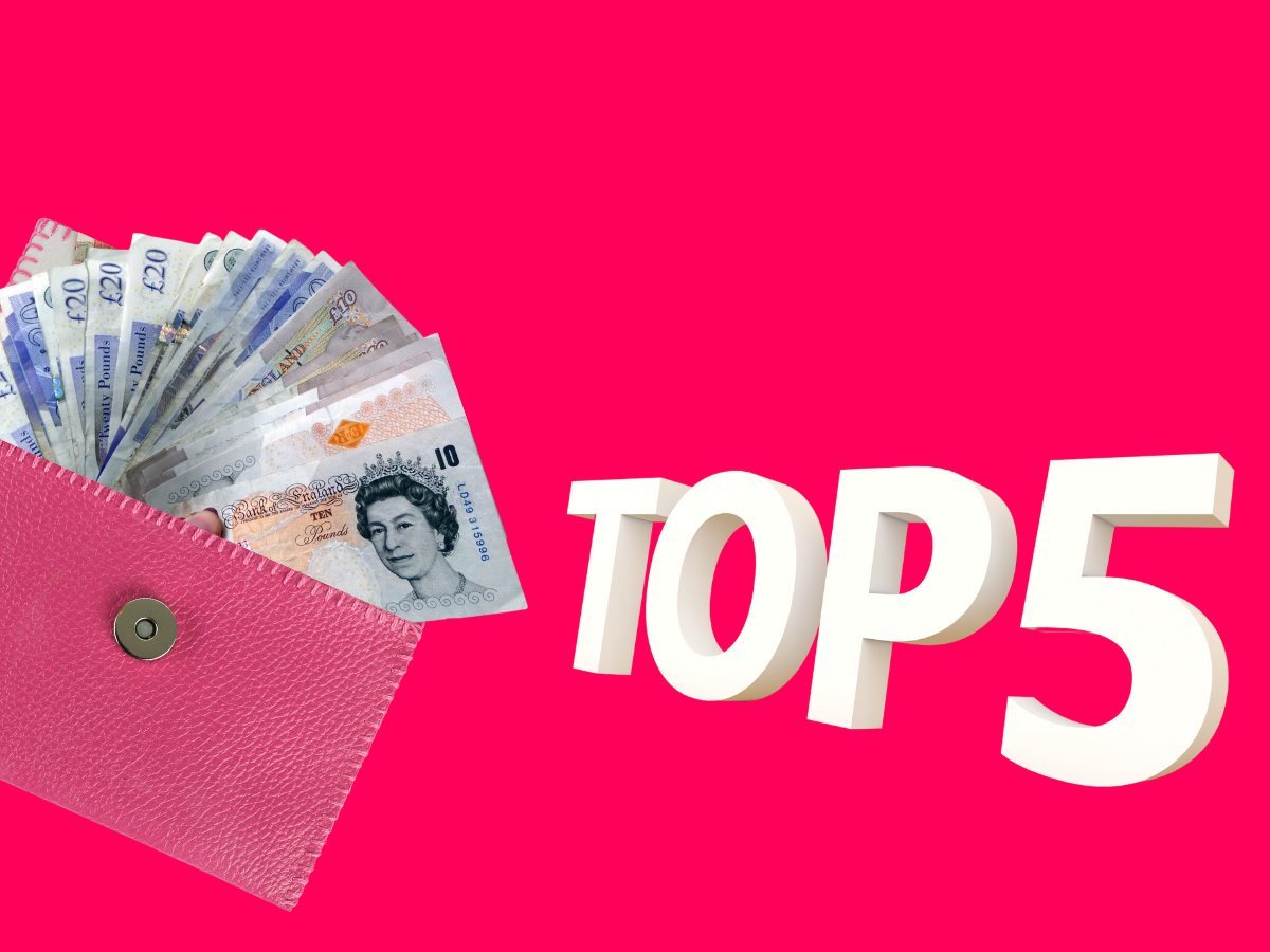 A pink purse filled with British pound notes sits next to large white 