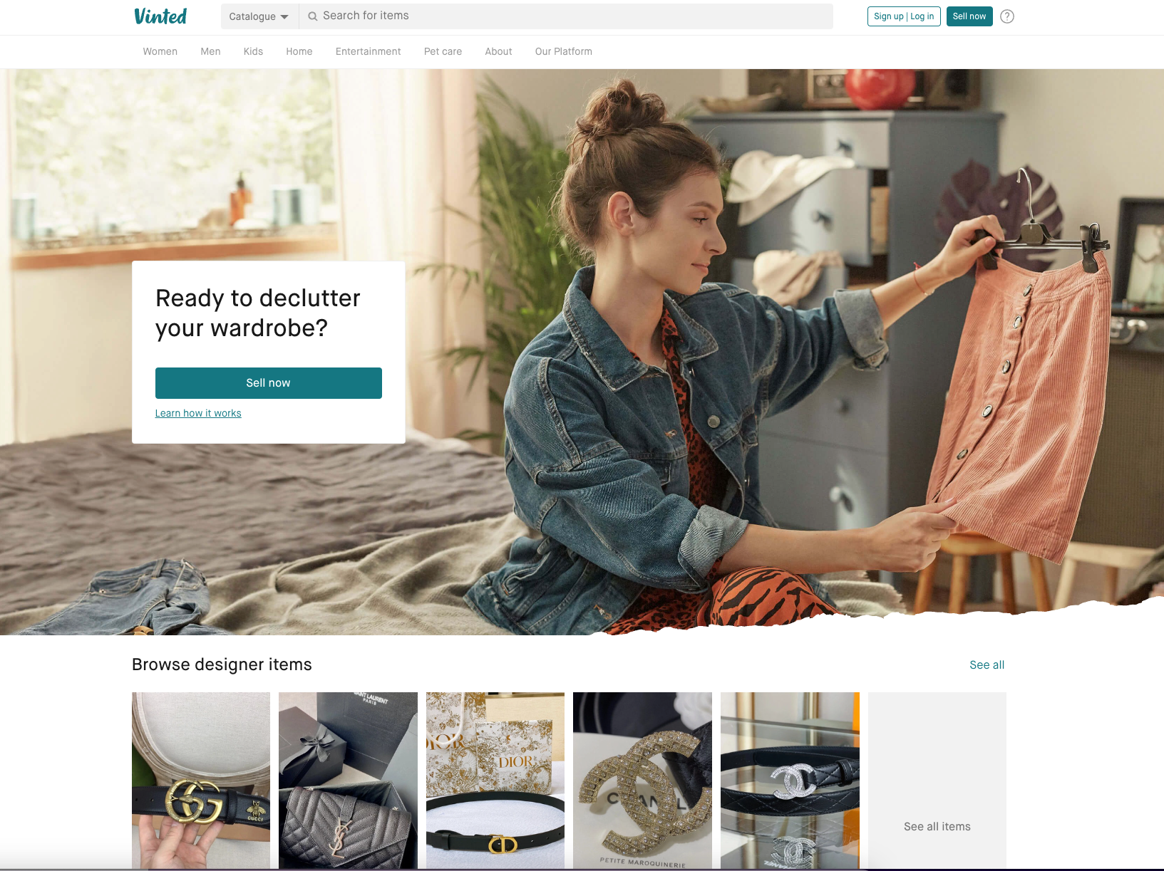 A person holding up a pink garment in a bedroom above a showcase of designer accessories on the Tradesy website.