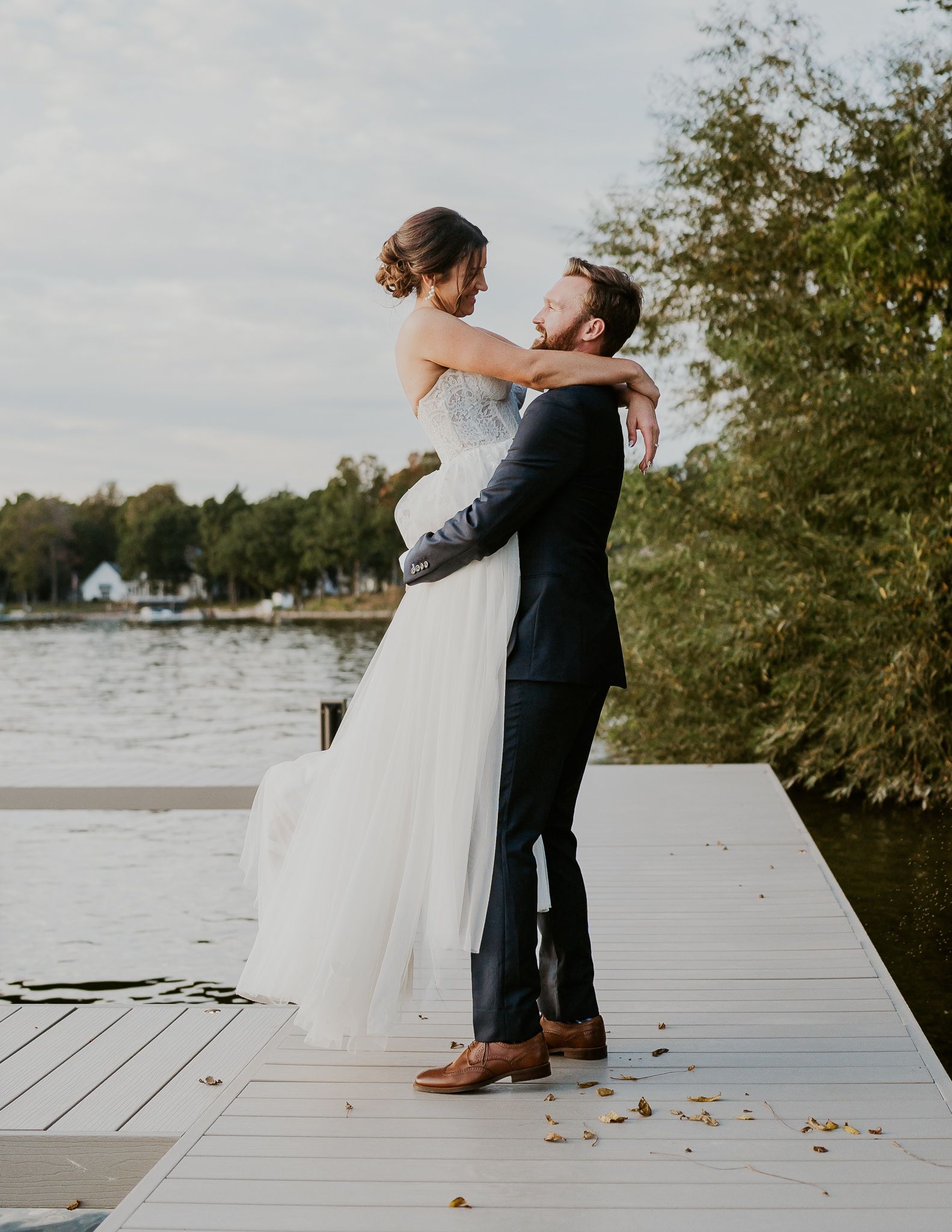 a bride and groom are posing for a picture in front of a tree .